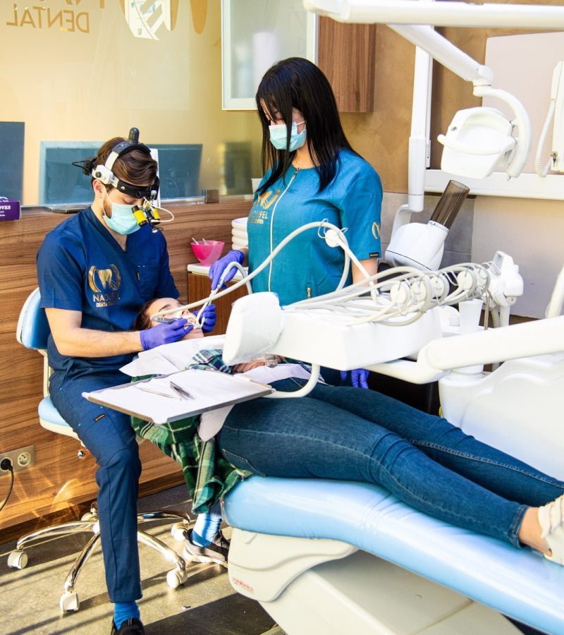 Chirurgien-dentiste et assistance médicale entrain de traiter un patient à la clinique dentaire Naoufel Dental Center à Constantine en Algérie, Cabinet dentaire à Constantine en Algérie